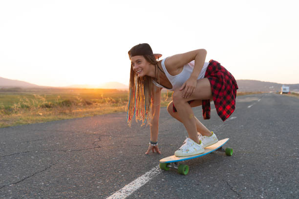 istock Beautiful girl with longboard skating on road 1096476636