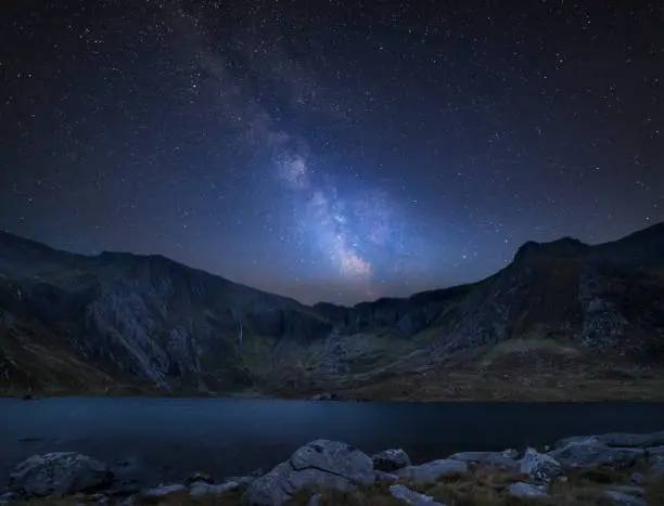 Stunning vibrant Milky Way composite image over Beautiful landscape image of Llyn Idwal and Devil's Kitchen in Snowdoina