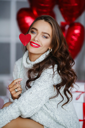 Fashion brunet girl model with red ballons