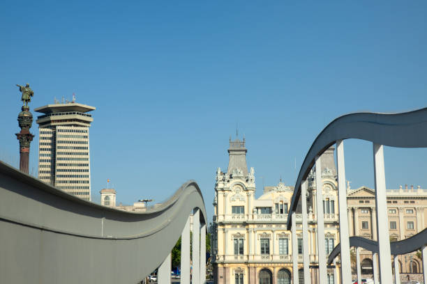 Barcelona, Spain - May 15, 2011: View of the city's old customs building and monument of Columbus in Port Vell from Rambla del Mar. Port Vell is a waterfront harbor in Barcelona, Catalonia, Spain, and part of the Port of Barcelona. It was built as part of an urban renewal program prior to the 1992 Barcelona Olympics