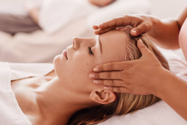 istock woman getting a head massage from massage therapist 1096486916