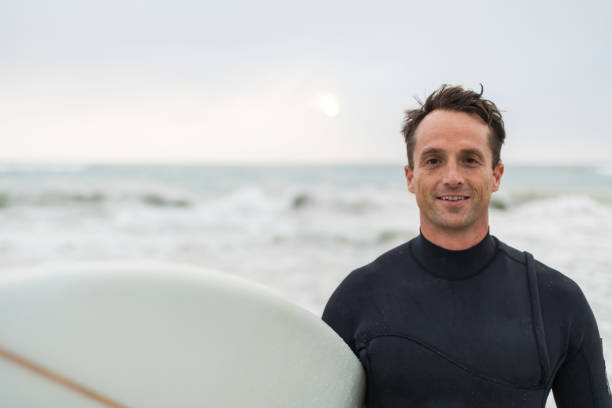 istock Portrait of a smiling surfer holding a surfboard 1096487272