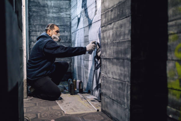 Street artist making a spray graffiti on the wall