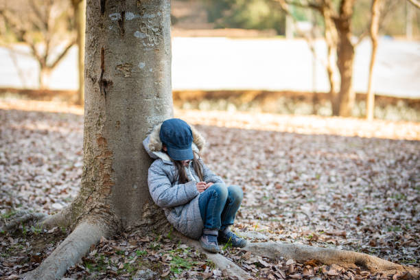 istock Girl to rest leaning against a tree 1096491954