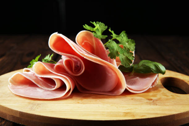 istock Sliced ham with parsley on table. Fresh prosciutto. Pork ham sliced. 1096497072