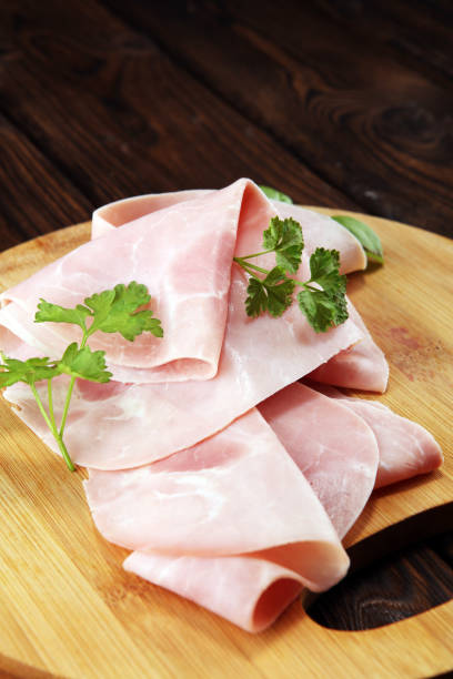 istock Sliced ham with parsley on table. Fresh prosciutto. Pork ham sliced. 1096499018