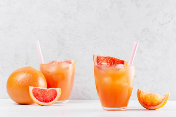 istock Two glasses of fresh grapefruit juice on the white table 1096499054
