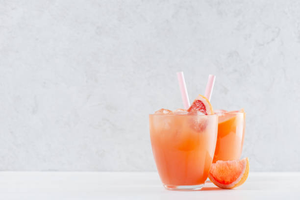 istock Two glasses of fresh grapefruit juice on the white table 1096499162