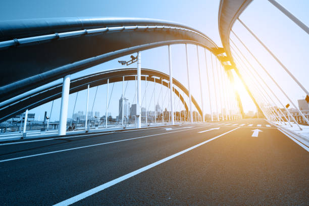 Asphalt highway under the urban steel frame bridge