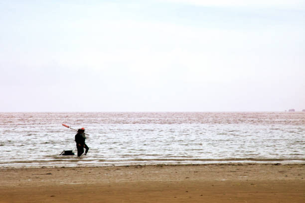 istock Fisherman silhouetted picking shellfish and equipment 1096514056