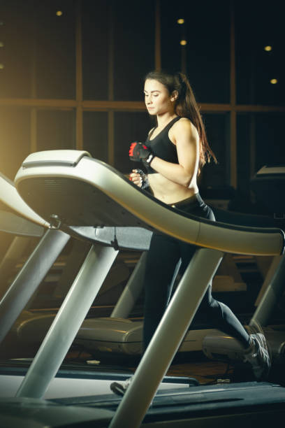 istock Young attractive woman running on treadmill 1096514070