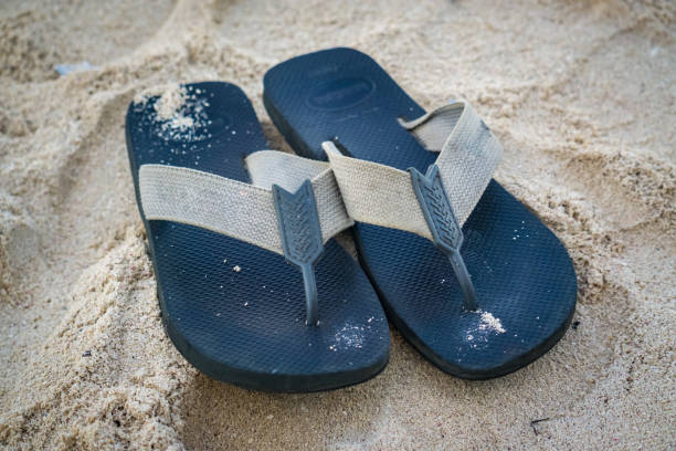 Black Sandals in the sand stock photo