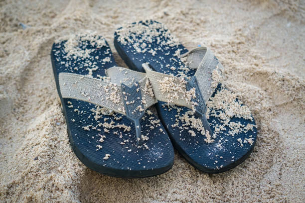 Black Sandals in the sand stock photo