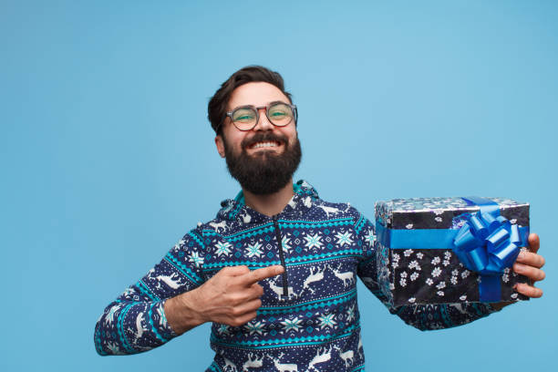 istock an with beard holding and pointing finger at gift box 1096522318