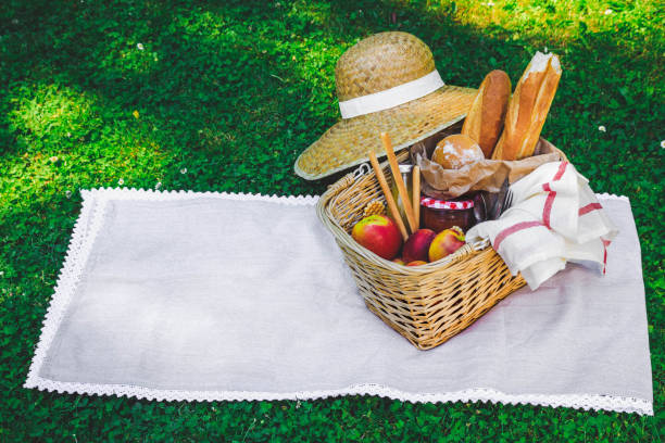 istock Hat, straw basket with food and drinks on beige plaid . 1096522960