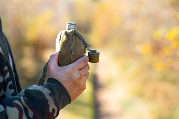 aluminum canteen in hands of hiker, outdoors - military canteen imagens e fotografias de stock