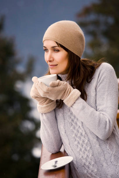 istock woman drinking a hot drink in the snow 1096542510