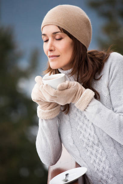 istock woman drinking a hot drink in the snow 1096545478