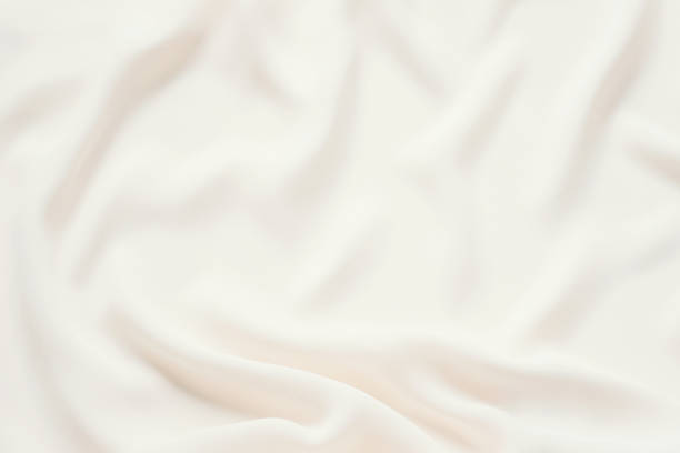 Matte cream delicate soft pleated fabric background. Smooth elegant luxury cloth texture. Gentle pastel color wedding background