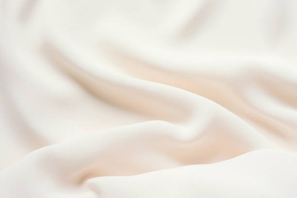 istock Matte cream delicate soft pleated fabric background. Smooth elegant luxury cloth texture. Gentle pastel color wedding background 1096545744