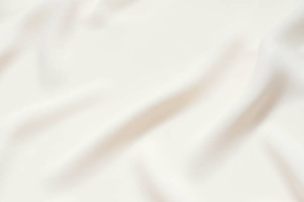 istock Matte cream delicate soft pleated fabric background. Smooth elegant luxury cloth texture. Gentle pastel color wedding background 1096545790