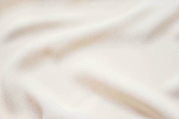 Matte cream delicate soft pleated fabric background. Smooth elegant luxury cloth texture. Gentle pastel color wedding background