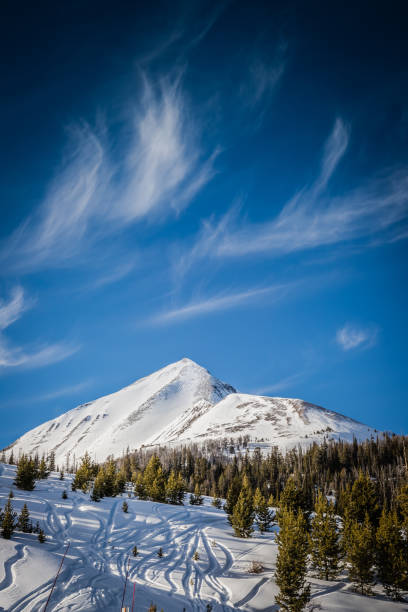 Wispy Clouds Wispy clouds float above Lone Peak on a blue bird winter day. big sky ski resort stock pictures, royalty-free photos & images