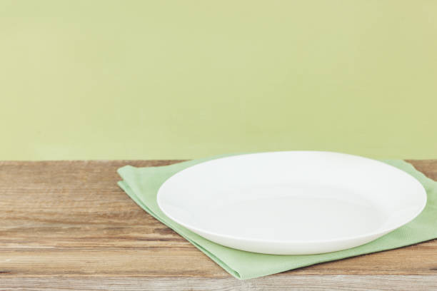 istock Empty plate on tablecloth or napkin on wooden table over cement background 1096547866