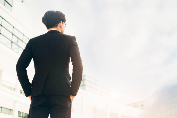 istock Back view of young smart successful businessman standing outside 1096556206