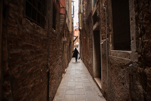 A woman walking the narrow streets of Venice