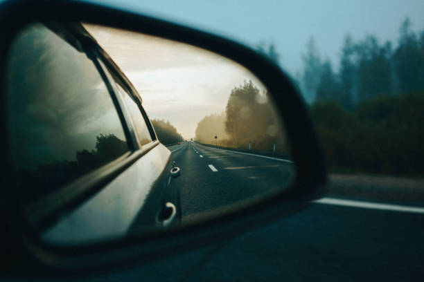 Reflection of asphalt highway road at the car side mirrow Reflection of asphalt highway road and sunrise at the car side mirrow rear view mirror stock pictures, royalty-free photos & images