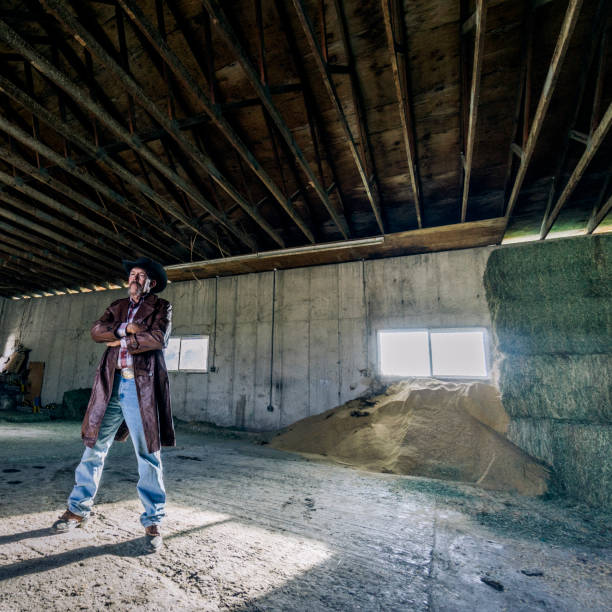 istock Inside a barn, a determined cowboy is standing with his arms crossed. 1096563952