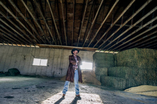 istock Inside a barn, a determined cowboy is standing with his arms crossed. 1096563960