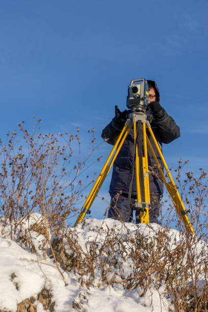 istock Surveyor conducts a topographical survey in winter for cadastral work at a construction site 1096568384