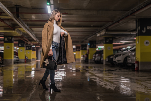 Fashionable young woman checking time in a public car garage.