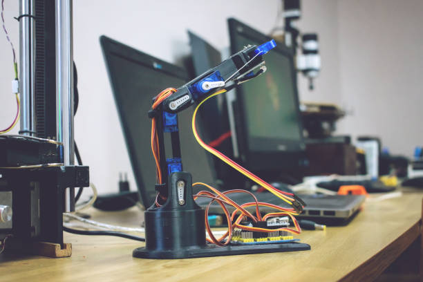 istock 3D printed robot arm with wires and control board. Plastic manipulator, robotic hand machine tool printed on three dimensional printer. DIY robotics, engineering, science, technology, computer code 1096581944