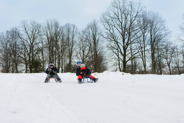 istock children on two sledges descend from the hills 1096585222