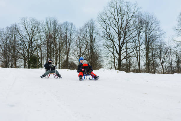 istock children on two sledges descend from the hills 1096585240