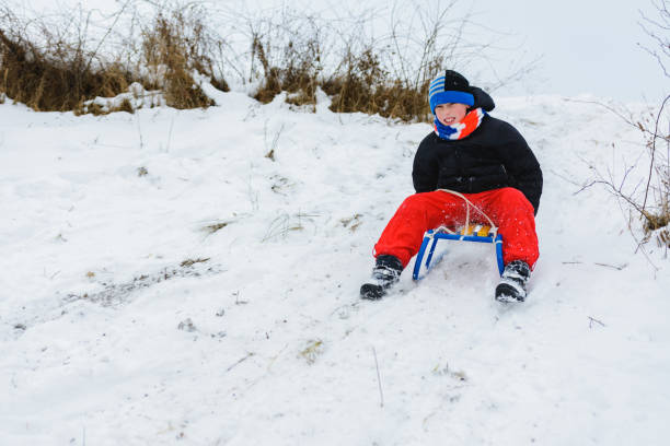 istock for a sledge down the boy in red pants is very happy 1096587442