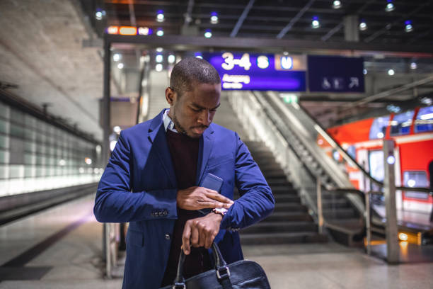 istock Quietly successful businessman checking the time on his wristwatch while waiting for his train 1096597330