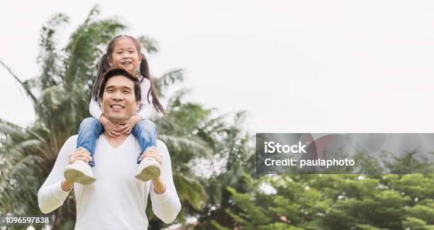 Asian Man Carry Piggyback Little Toddler Girl Cheerful Family Green Spring Or Summer Fathers Day Together Concept Banner Stock Photo - Download Image Now