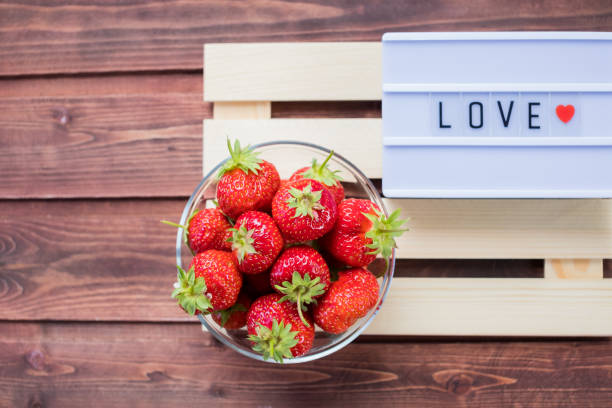 valentinstag, süßigkeiten und süßwaren konzept .word liebe auf lichtkasten und erdbeere über holzbretter hintergrund gemacht. valentinstag-grußkarte. romantischen hintergrund - dieting cookie food number stock-fotos und bilder