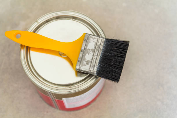 istock House renovation. Can with paint and a brush tool on concrete background 1096611610