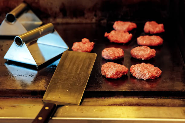 cooking burgers in the restaurant on the grill the kitchen of fast food restaurant griddle stock pictures, royalty-free photos & images