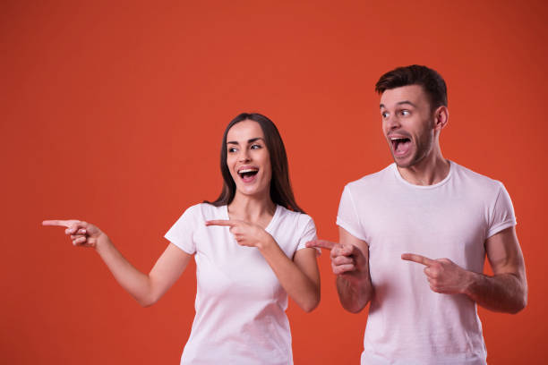 istock Beautiful young couple in white blank t-shirts are posing in studio 1096613280