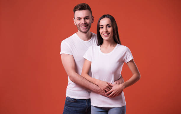 istock Beautiful young couple in white blank t-shirts are posing in studio 1096617074