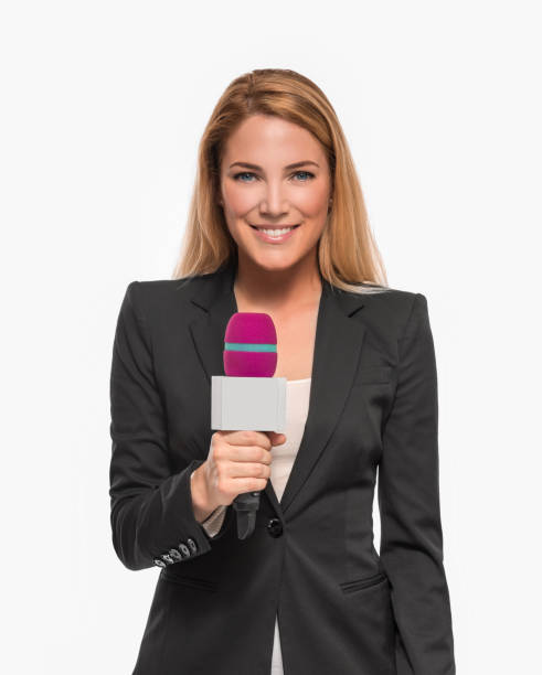 Attractive blonde TV presenter holding a microphone and points to an object. Attractive blonde TV presenter on white background holding a microphone and points to an object. newscaster stock pictures, royalty-free photos & images
