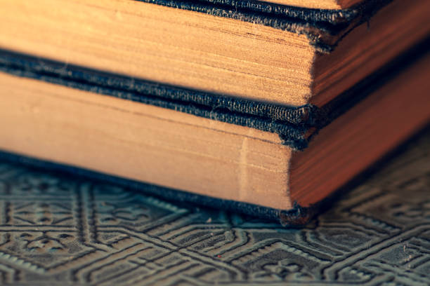 istock Old worn books stacked on textured surface close up 1096624654