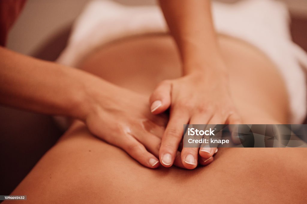 woman getting a back massage woman getting a back massage at a spa 
Photo taken indoors with stobe light Massaging Stock Photo