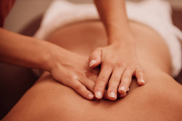 женщина получает массаж спины - спа процедура стоковые фото и изображения